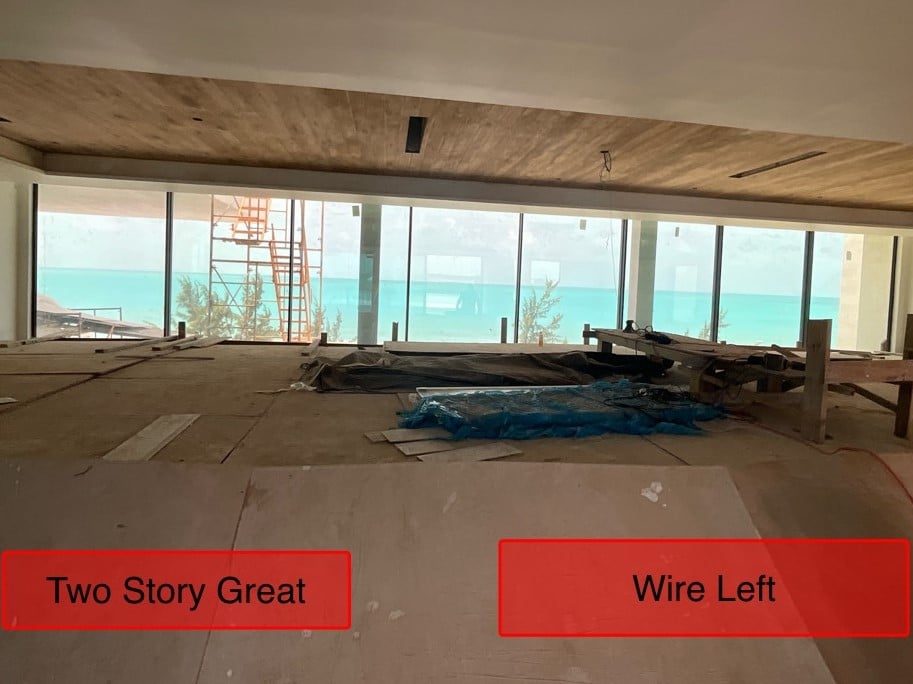 View of the two-story great room under construction, featuring a large window with a view of the beach