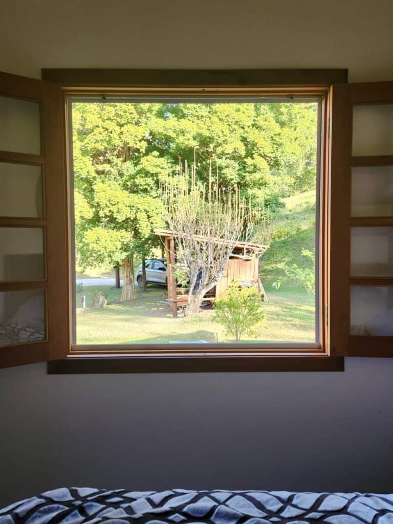 An open window showcasing a scenic view of nature and trees outside