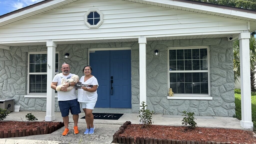 Roger & Ana Magalhaes, and their dog posing happily in front of their new house in Tampa.