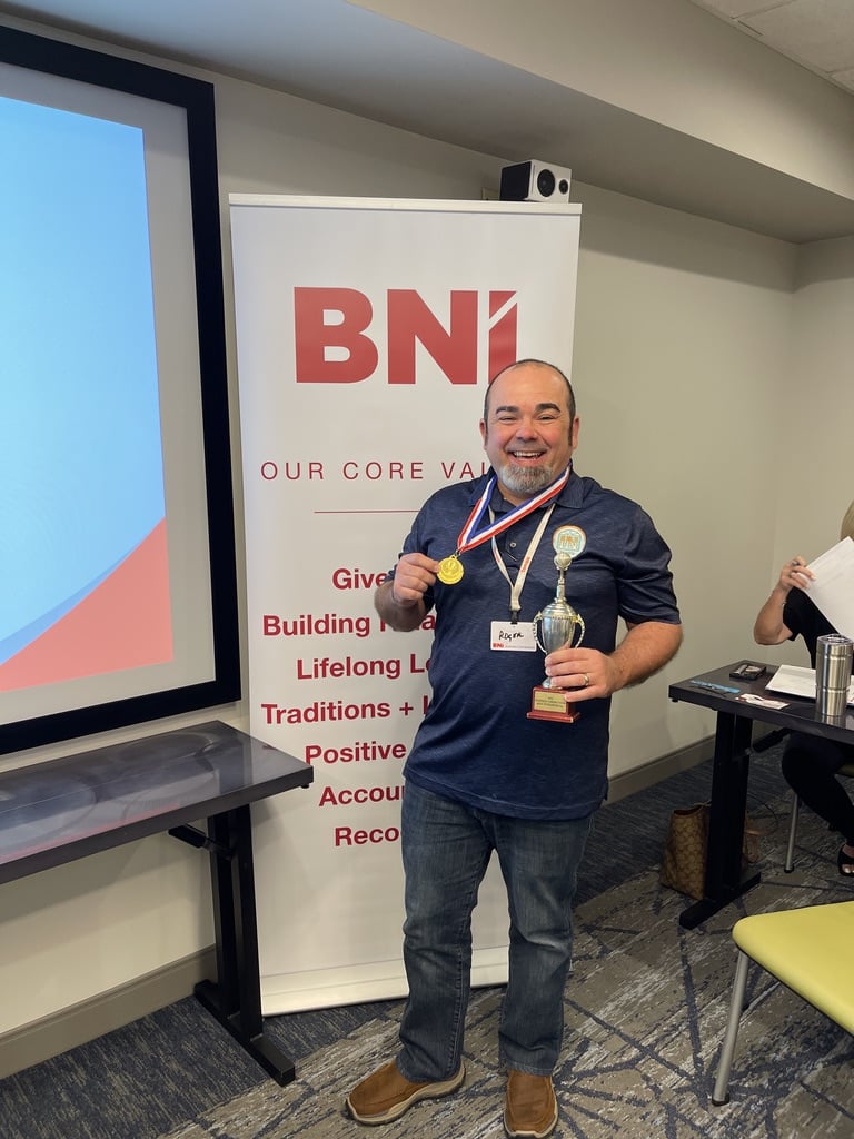 Roger Magalhaes proudly displaying an award at a BNI meeting.