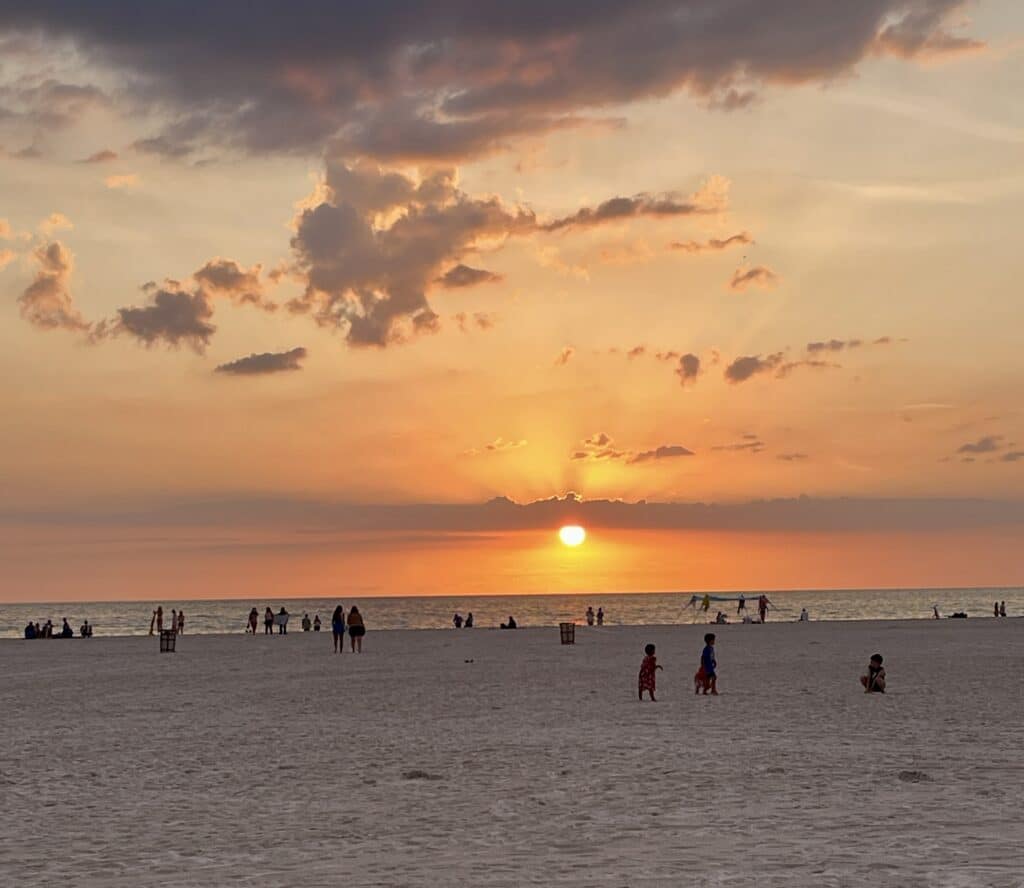 Beach at sunset, showcasing vibrant pink and orange hues in the sky.