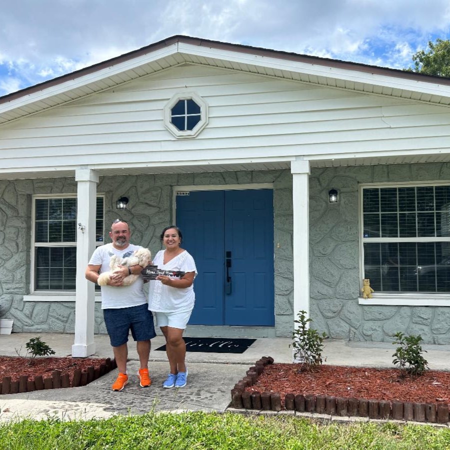 Roger & Ana Magalhaes, and their dog posing happily in front of their new house in Tampa.