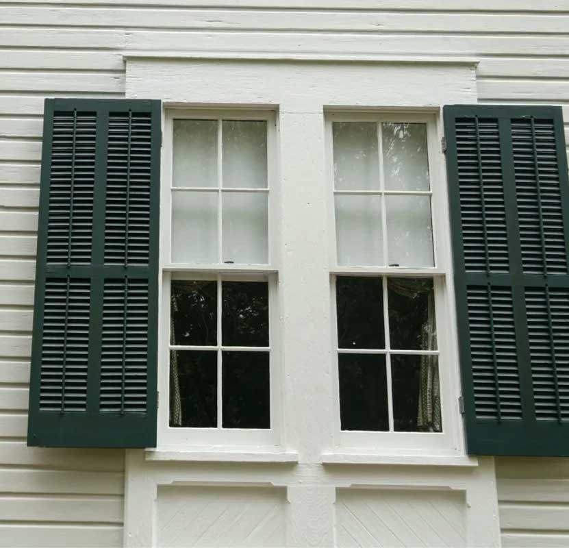 Green colonial shutters on home