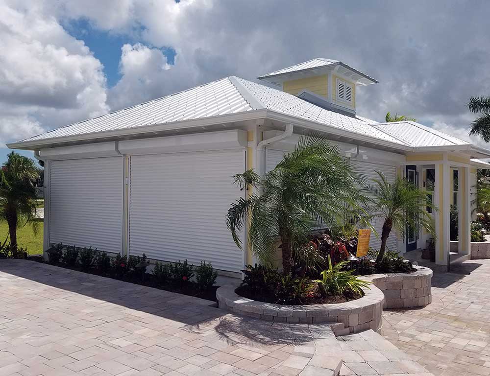 Yellow home during storm with roll down screens protecting windows